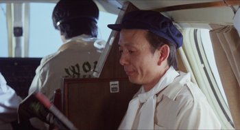 Movie still from “The In-Laws” (1979), directed by Arthur Hiller – A man sitting in a chair on top of an airplane; Close Up shot, Over the shoulder angle