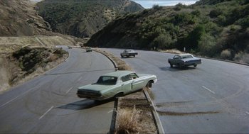 Movie still from “The In-Laws” (1979), directed by Arthur Hiller – An image of cars driving down the road; Extreme Wide shot, High angle