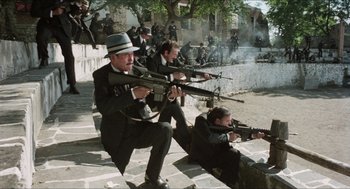 Movie still from “The In-Laws” (1979), directed by Arthur Hiller – A group of men dressed in suits and ties holding guns; Wide shot, High angle