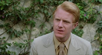 Movie still from “The In-Laws” (1979), directed by Arthur Hiller – A person wearing a suit and tie; Close Up shot, Over the shoulder angle
