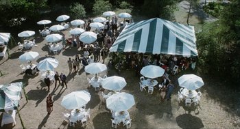 Movie still from “The In-Laws” (1979), directed by Arthur Hiller – An aerial view of a party with tables , chairs , and umbrellas; Extreme Wide shot, High angle