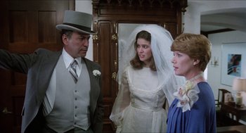 Movie still from “The In-Laws” (1979), directed by Arthur Hiller – Two women and a man in a wedding dress and top hat; Medium shot, Over the shoulder angle