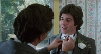 Movie still from “The In-Laws” (1979), directed by Arthur Hiller – A man adjusting the tie of another man's neck tie; Close Up shot, Over the shoulder angle