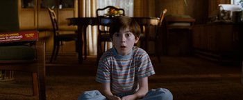 Movie still from “The Incredible Burt Wonderstone” (2013), directed by Don Scardino – A boy sitting on the ground in a room; Medium shot, High angle