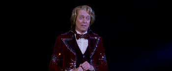 Movie still from “The Incredible Burt Wonderstone” (2013), directed by Don Scardino – An older man in a red jacket and a bow tie; Medium shot, Low angle