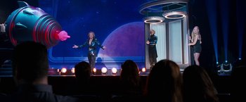 Movie still from “The Incredible Burt Wonderstone” (2013), directed by Don Scardino – A woman and a man stand on a stage in front of an audience; Wide shot, Low angle