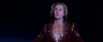Movie still from “The Incredible Burt Wonderstone” (2013), directed by Don Scardino – A man with long hair wearing a red jacket and gold jewelry; Close Up shot, Low angle