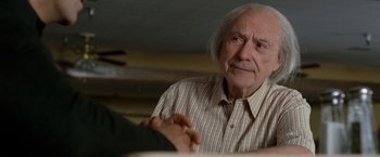 Movie still from “The Incredible Burt Wonderstone” (2013), directed by Don Scardino – An older man sitting in front of a table; Close Up shot, Over the shoulder angle