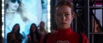 Movie still from “The Incredible Burt Wonderstone” (2013), directed by Don Scardino – A woman in a red outfit standing in front of a crowd of onlookers; Close Up shot, Over the shoulder angle