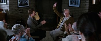 Movie still from “The Incredible Burt Wonderstone” (2013), directed by Don Scardino – An older man sitting in front of an older man holding a guitar; Wide shot, Over the shoulder angle