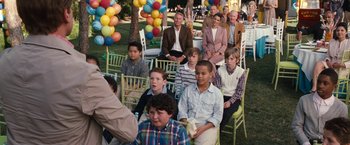 Movie still from “The Incredible Burt Wonderstone” (2013), directed by Don Scardino – A group of people sitting at a table with balloons; Wide shot, Over the shoulder angle