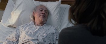 Movie still from “The Incredible Burt Wonderstone” (2013), directed by Don Scardino – An older man in a hospital bed talking to a woman; Medium shot, High angle