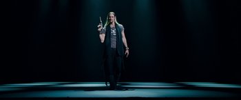 Movie still from “The Incredible Burt Wonderstone” (2013), directed by Don Scardino – A man with long blonde hair is holding a pen in his hand; Medium shot, Low angle