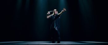 Movie still from “The Incredible Burt Wonderstone” (2013), directed by Don Scardino – A man standing on a stage with his hands up; Medium shot, Low angle