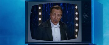 Movie still from “The Incredible Burt Wonderstone” (2013), directed by Don Scardino – A man in a suit and bow tie is on a television screen; Medium shot, Low angle