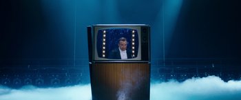 Movie still from “The Incredible Burt Wonderstone” (2013), directed by Don Scardino – A man in a tuxedo is sitting in front of an old tv; Wide shot, Over the shoulder angle