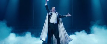 Movie still from “The Incredible Burt Wonderstone” (2013), directed by Don Scardino – A man in a tuxedo and a cape on a stage; Medium shot, Low angle