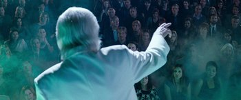 Movie still from “The Incredible Burt Wonderstone” (2013), directed by Don Scardino – An old man in a white shirt is pointing at a crowd of onlookers; Medium shot, Over the shoulder angle