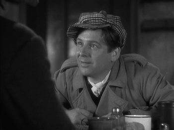 Movie still from “The Informer” (1935), directed by John Ford – A black and white photo of a man wearing a hat; Close Up shot, Over the shoulder angle