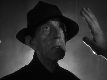 Movie still from “The Informer” (1935), directed by John Ford – An older man wearing a hat and a black shirt; Close Up shot, Low angle