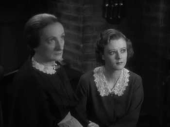 Movie still from “The Informer” (1935), directed by John Ford – A couple of women standing next to each other; Close Up shot, High angle