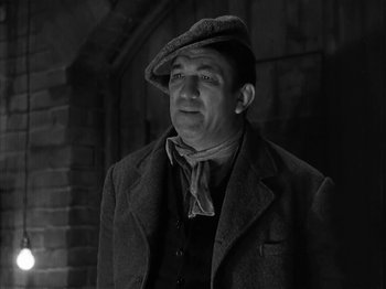 Movie still from “The Informer” (1935), directed by John Ford – A man wearing a hat and a jacket; Medium shot, Low angle