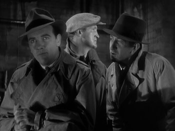 Movie still from “The Informer” (1935), directed by John Ford – A group of men standing next to each other; Medium shot, Low angle