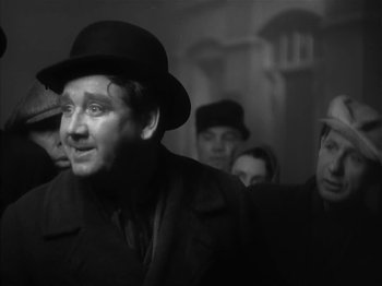 Movie still from “The Informer” (1935), directed by John Ford – A group of people standing in a room; Close Up shot, Low angle