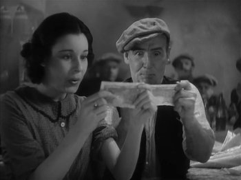 Movie still from “The Informer” (1935), directed by John Ford – A man and a woman looking at a piece of paper; Close Up shot, Low angle