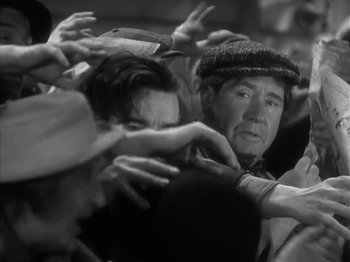 Movie still from “The Informer” (1935), directed by John Ford – An old man is surrounded by a group of people; Close Up shot, High angle