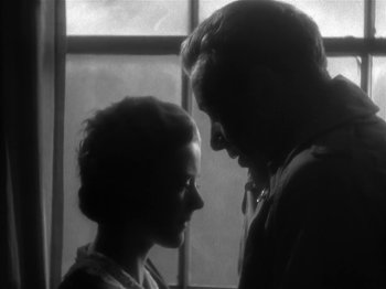 Movie still from “The Informer” (1935), directed by John Ford – A man and a woman looking at one another; Close Up shot, Low angle