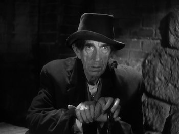 Movie still from “The Informer” (1935), directed by John Ford – An old man wearing a hat and holding a cane; Close Up shot, Low angle