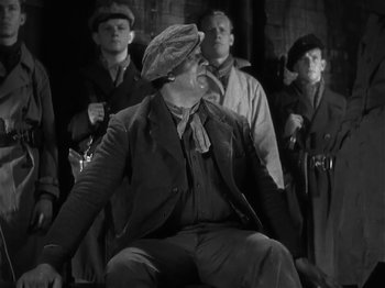 Movie still from “The Informer” (1935), directed by John Ford – A group of men standing next to each other; Medium shot, Low angle