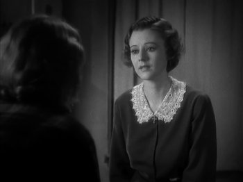 Movie still from “The Informer” (1935), directed by John Ford – A woman in a black dress is looking at a mirror; Close Up shot, High angle