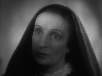 Movie still from “The Informer” (1935), directed by John Ford – An older woman wearing a black veil and a white dress; Close Up shot, High angle