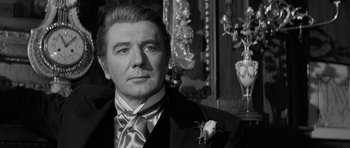 Movie still from “The Innocents” (1961), directed by Jack Clayton – A black and white photo of a man in a suit and tie; Close Up shot, Over the shoulder angle