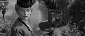 Movie still from “The Innocents” (1961), directed by Jack Clayton – A black and white photo of a woman in a hat; Close Up shot, Over the shoulder angle
