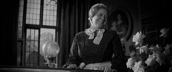 Movie still from “The Innocents” (1961), directed by Jack Clayton – An older woman in a black and white photo; Medium shot, Low angle
