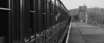 Movie still from “The Innocents” (1961), directed by Jack Clayton – A woman peeking out of a train window; Wide shot, Low angle