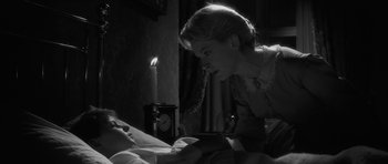 Movie still from “The Innocents” (1961), directed by Jack Clayton – A woman looking at a man laying in a bed; Close Up shot, Over the shoulder angle