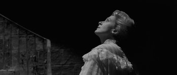 Movie still from “The Innocents” (1961), directed by Jack Clayton – A black and white photo of a woman looking up at the sky; Close Up shot, Low angle