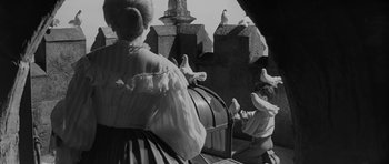 Movie still from “The Innocents” (1961), directed by Jack Clayton – A group of pigeons sitting on top of a wooden box; Medium shot, Low angle