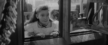 Movie still from “The Innocents” (1961), directed by Jack Clayton – A little girl looking out of a window; Close Up shot, High angle