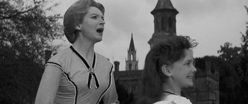 Movie still from “The Innocents” (1961), directed by Jack Clayton – A woman is singing in front of two other women; Close Up shot, Low angle