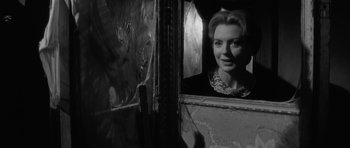 Movie still from “The Innocents” (1961), directed by Jack Clayton – A black - and - white photo of a woman looking into a mirror; Close Up shot, Over the shoulder angle
