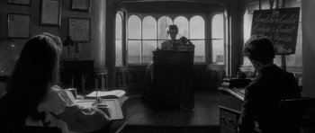 Movie still from “The Innocents” (1961), directed by Jack Clayton – A man sitting in front of an open window; Wide shot, Low angle