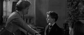Movie still from “The Innocents” (1961), directed by Jack Clayton – A young man and a young woman in a room; Medium shot, Over the shoulder angle