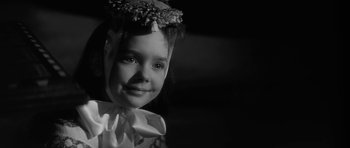 Movie still from “The Innocents” (1961), directed by Jack Clayton – A little girl wearing a bow and a flower crown; Close Up shot, High angle