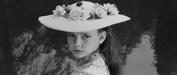 Movie still from “The Innocents” (1961), directed by Jack Clayton – A young girl wearing a hat with flowers on it; Close Up shot, High angle