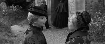 Movie still from “The Innocents” (1961), directed by Jack Clayton – Two women talking to each other in front of a building; Medium shot, Over the shoulder angle